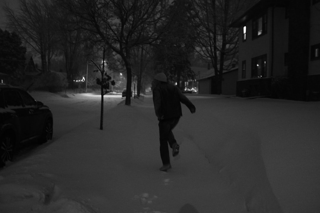 Person running on a snowy street at night